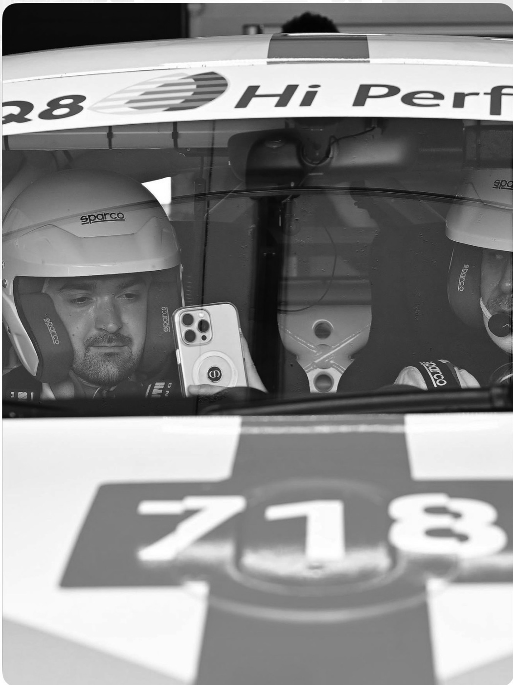 Simone Guiducci con casco e tuta Sparco a bordo di una Porsche 718 da competizione, pronto in pista per un track day